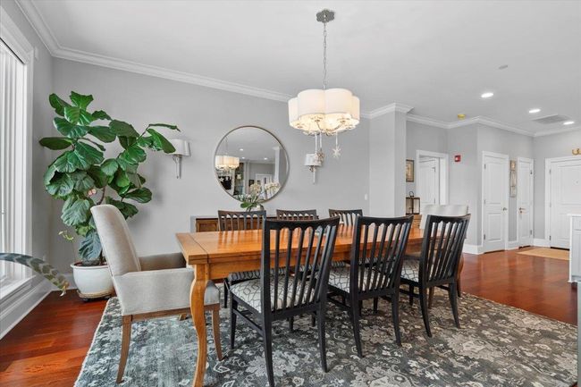 Dining room featuring an inviting chandelier, ornamental molding, and wood finished floors | Image 6