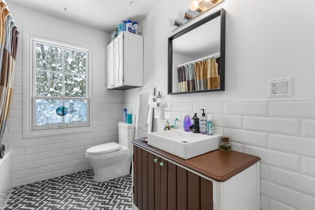 Bathroom featuring a wainscoted wall, toilet, vanity, and a shower with curtain | Image 20