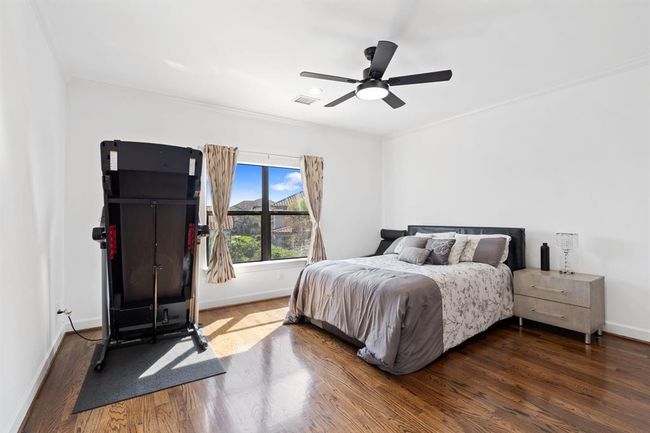 Charming secondary bedroom with hardwood flooring, an oversized window, and a ceiling fan for added comfort. Conveniently connected to a well-appointed Jack and Jill bathroom. | Image 42