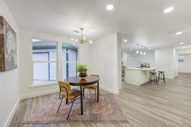 The luxury vinyl flooring continues seamlessly from the kitchen into the breakfast room, creating a cohesive flow. With its open layout, this space is ideal for family meals or as a cozy nook for reading and relaxing. The fresh paint and modern finishes ensure this room is both stylish and functional. | Image 9