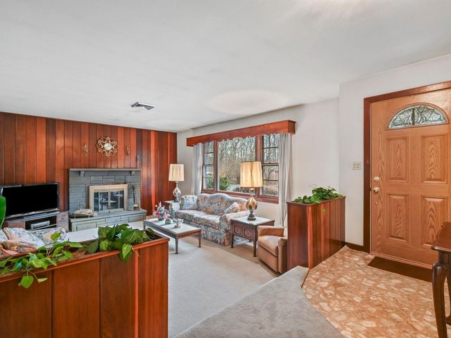 Living room featuring wood walls and light colored carpet | Image 14