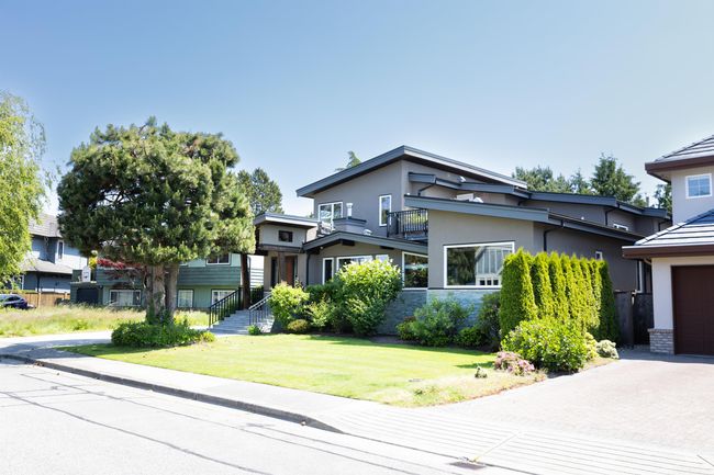 Modern home featuring stucco siding, a balcony, a front yard, and driveway | Image 36