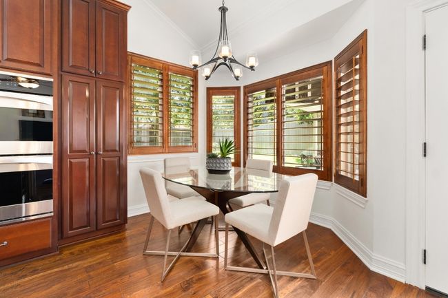 Dining room featuring a chandelier, vaulted ceiling, dark wood-style floors, plenty of natural light, and crown molding | Image 12
