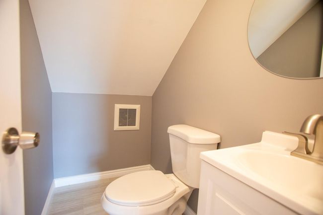 Bathroom featuring vanity, toilet, and lofted ceiling | Image 24