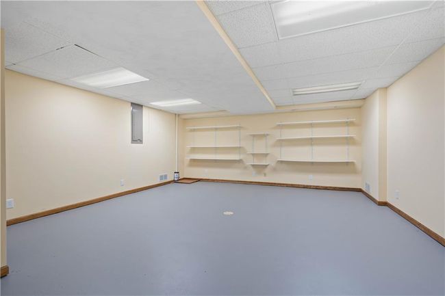 Finished basement featuring visible vents, baseboards, and a paneled ceiling | Image 19