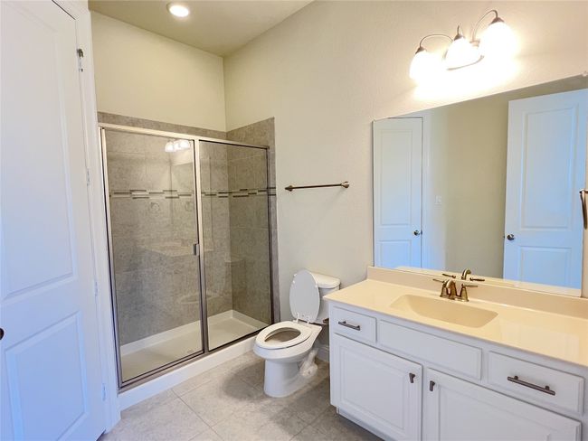 Bathroom featuring vanity, tile patterned floors, and a stall shower | Image 15
