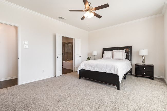 Carpeted bedroom with ornamental molding, visible vents, baseboards, and a ceiling fan | Image 17
