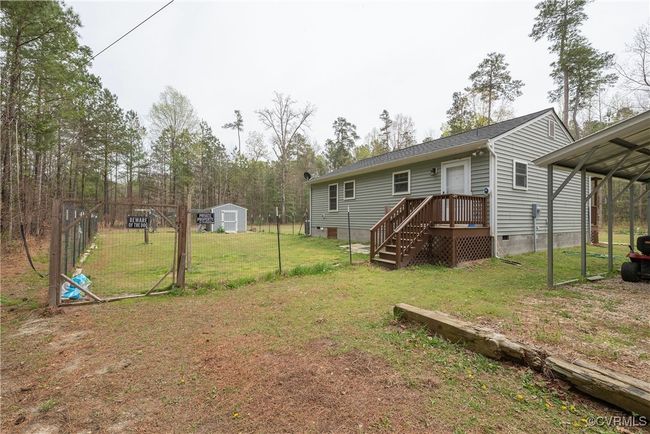 Back of house with an outdoor structure, a lawn, a storage unit, crawl space, and a detached carport | Image 36
