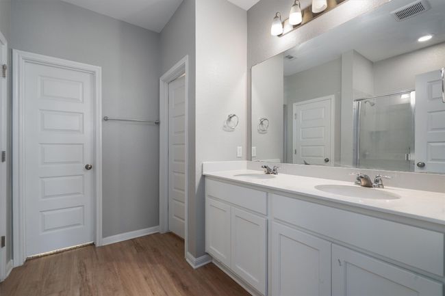 Full bath with a shower with door, double vanity, and wood finished floors | Image 13