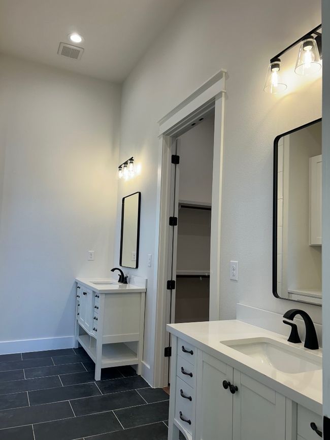 Bathroom featuring tile patterned flooring, two vanities, and baseboards | Image 14