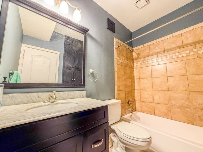 Bathroom featuring shower / bathtub combination, vanity, and a textured wall | Image 19