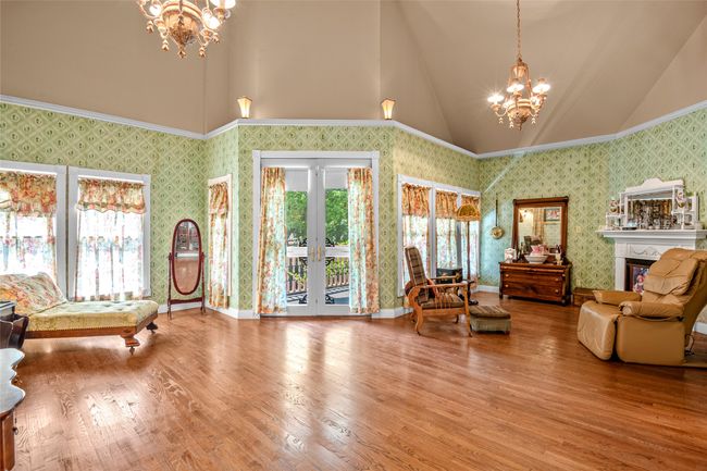 Living area featuring a chandelier, lofted ceiling, french doors, and wood finished floors | Image 25