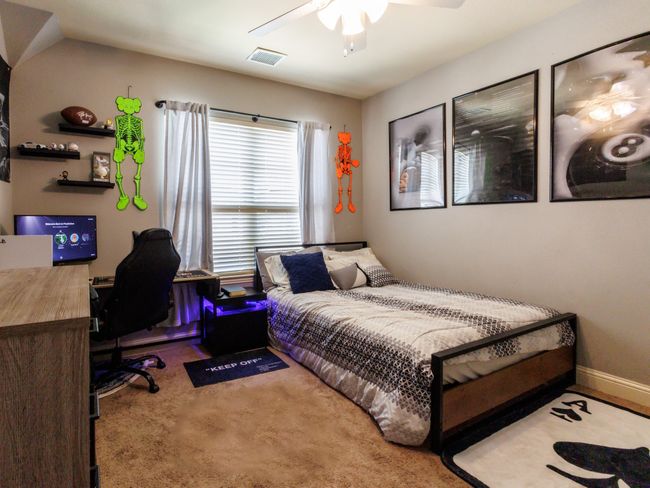 High ceilings, a ceiling fan, and a sizeable window in this bedroom. | Image 25