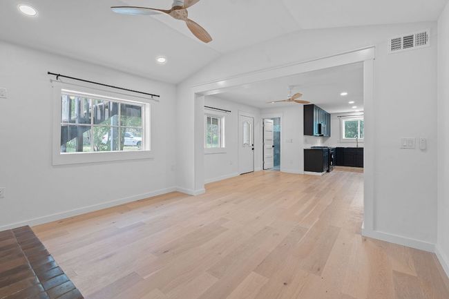 Unfurnished living room featuring ceiling fan, lofted ceiling, light wood finished floors, and recessed lighting | Image 6