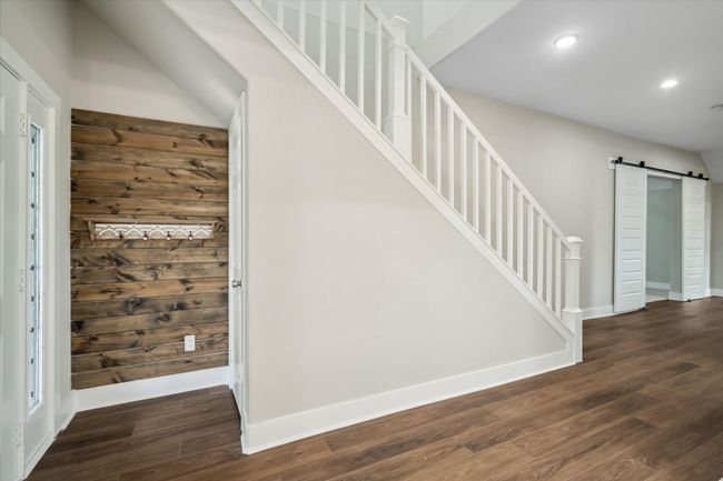 Stairway featuring a barn door, recessed lighting, wood finished floors, and baseboards | Image 5