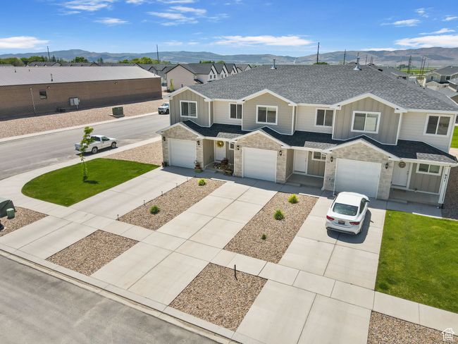 Multi unit property with board and batten siding, a mountain view, a shingled roof, and driveway | Image 6
