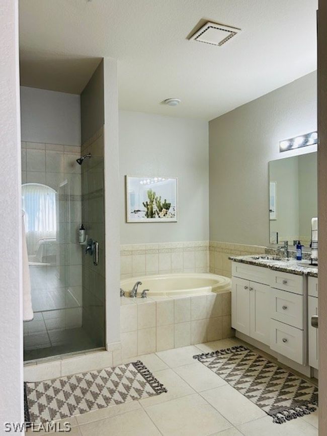 Bathroom featuring tile flooring, oversized vanity, and plus walk in shower | Image 18