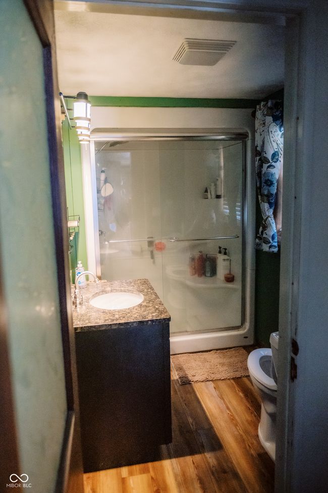 bathroom featuring vanity, toilet, a shower stall, visible vents, and wood finished floors | Image 28