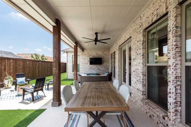 Fenced backyard featuring a patio, ceiling fan, and outdoor dining space | Image 37