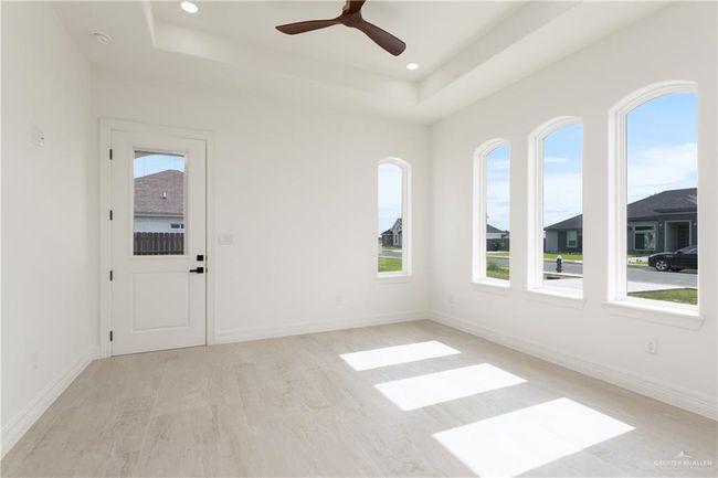 Apartment Living Area with Natural LightOpen living space with tray ceiling, recessed lighting, and multiple arched windows that flood the room with natural light. | Image 32