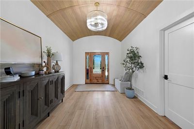 Entryway featuring wood ceiling, an inviting chandelier, and light hardwood / wood-style floors | Image 3