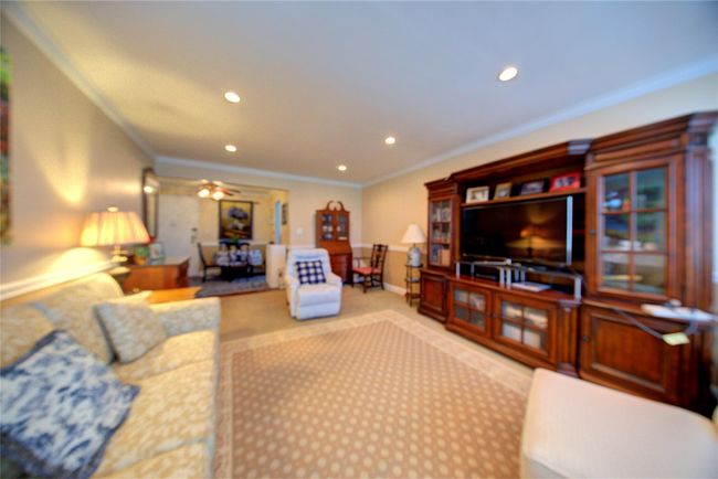Living room with ceiling fan, recessed lighting, light colored carpet, baseboards, and crown molding | Image 14