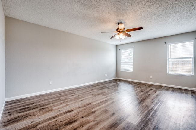 Spare room featuring a ceiling fan, wood finished floors, a textured ceiling, and baseboards | Image 12