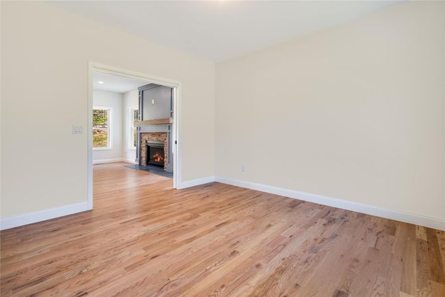 Unfurnished living room featuring plenty of natural light, light wood-type flooring, and ceiling fan | Image 4