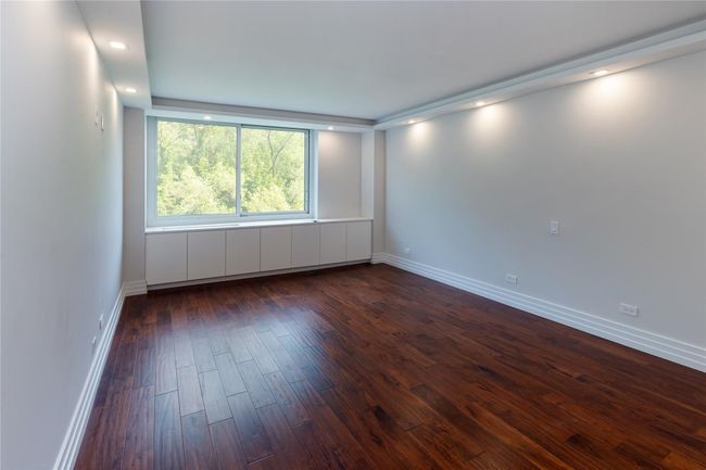 Empty room with dark wood-style flooring and baseboards | Image 12