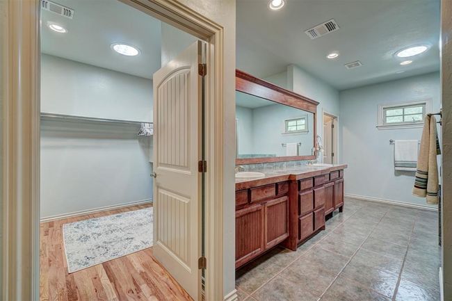 Full bathroom featuring a walk in closet, a sink, visible vents, and double vanity | Image 25