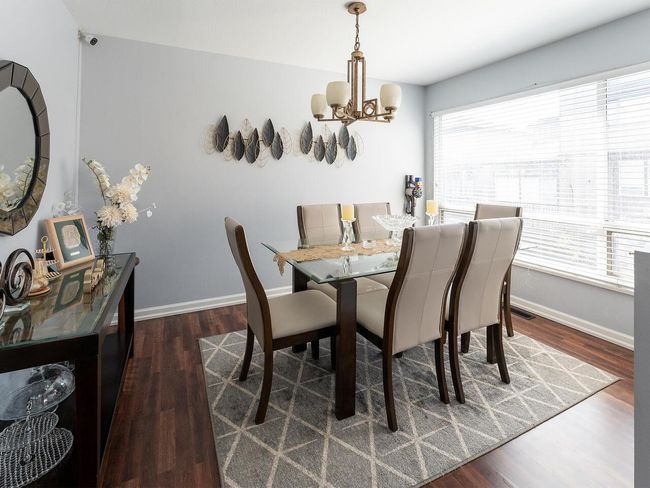 Dining area with baseboards, visible vents, wood finished floors, and an inviting chandelier | Image 9