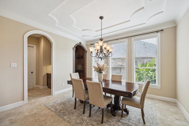 A formal dining fit for a king with an elegant accent ceiling, beautiful millwork on all archways, lovely views of the garden, and a wine grotto | Image 10