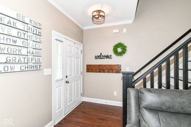 foyer entrance with ornamental molding, baseboards, dark wood-style flooring, and stairway | Image 28