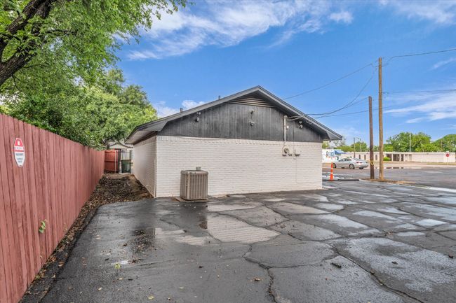 Rear view of house with brick siding, fence, a patio area, and central AC unit | Image 17