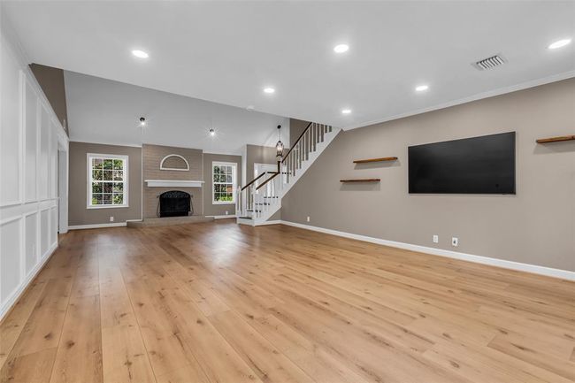 A very spacious living room with a wood-burning fireplace. | Image 11