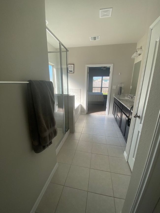 Bathroom with baseboards, a stall shower, tile patterned floors, visible vents, and a garden tub | Image 18