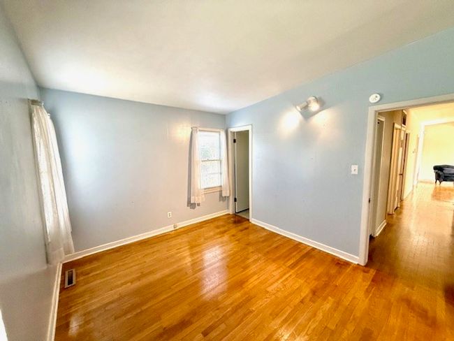 Empty room with baseboards, visible vents, and wood finished floors | Image 9