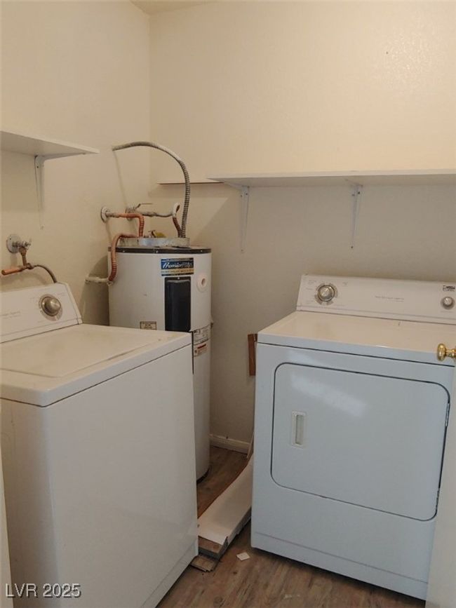 Clothes washing area with water heater, dark hardwood / wood-style flooring, and washing machine and clothes dryer | Image 13