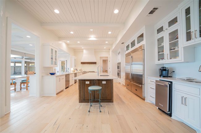 Kitchen featuring appliances with stainless steel finishes, light wood-type flooring, premium range hood, light countertops, and recessed lighting | Image 17