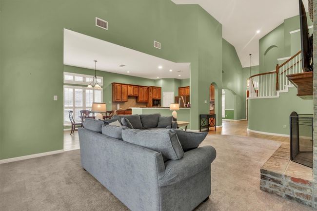 Living area with baseboards, visible vents, arched walkways, and high vaulted ceiling | Image 6