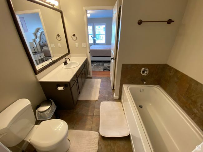 Ensuite bathroom featuring a garden tub, vanity, toilet, and tile patterned floors | Image 12
