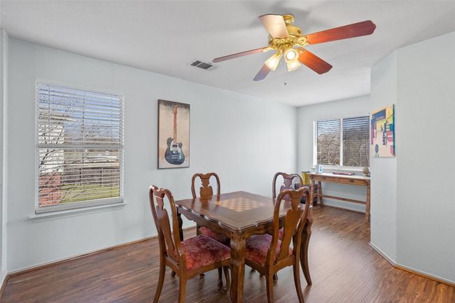 Dining area with plenty of natural light, visible vents, ceiling fan, and wood finished floors | Image 16
