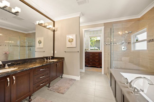 Bathroom with a shower stall, double vanity, crown molding, and a garden tub | Image 14