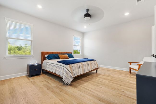 Bedroom with baseboards, light wood finished floors, recessed lighting, and a ceiling fan | Image 11