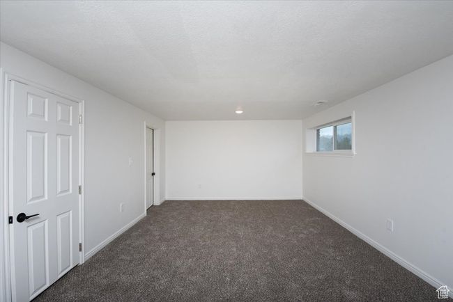 Unfurnished room featuring baseboards and dark colored carpet | Image 24