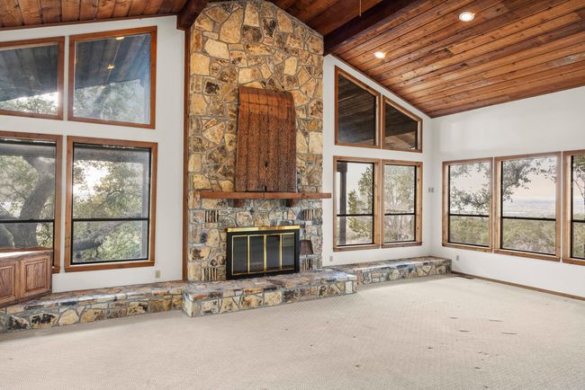 Unfurnished living room featuring wood ceiling, carpet, a fireplace, and recessed lighting | Image 19