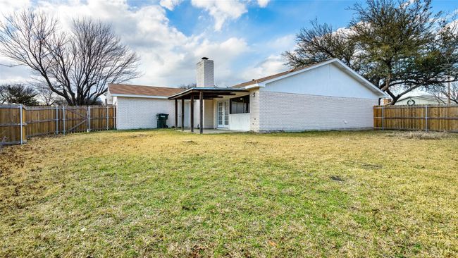 Back of house with brick siding, a fenced backyard, and a lawn | Image 30