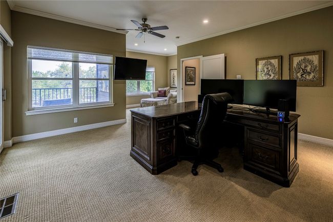 Expansive upstairs office with beautiful view of backyard, porch, sitting areas inside and out, crown molding and a ceiling fan | Image 6