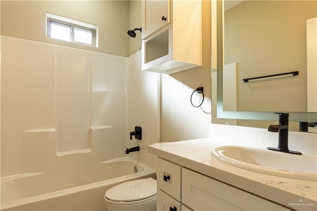 Bathroom with toilet, bathing tub / shower combination, and vanity | Image 23