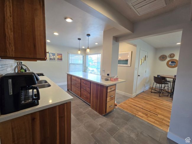 Kitchen featuring decorative light fixtures, light countertops, recessed lighting, and baseboards | Image 19